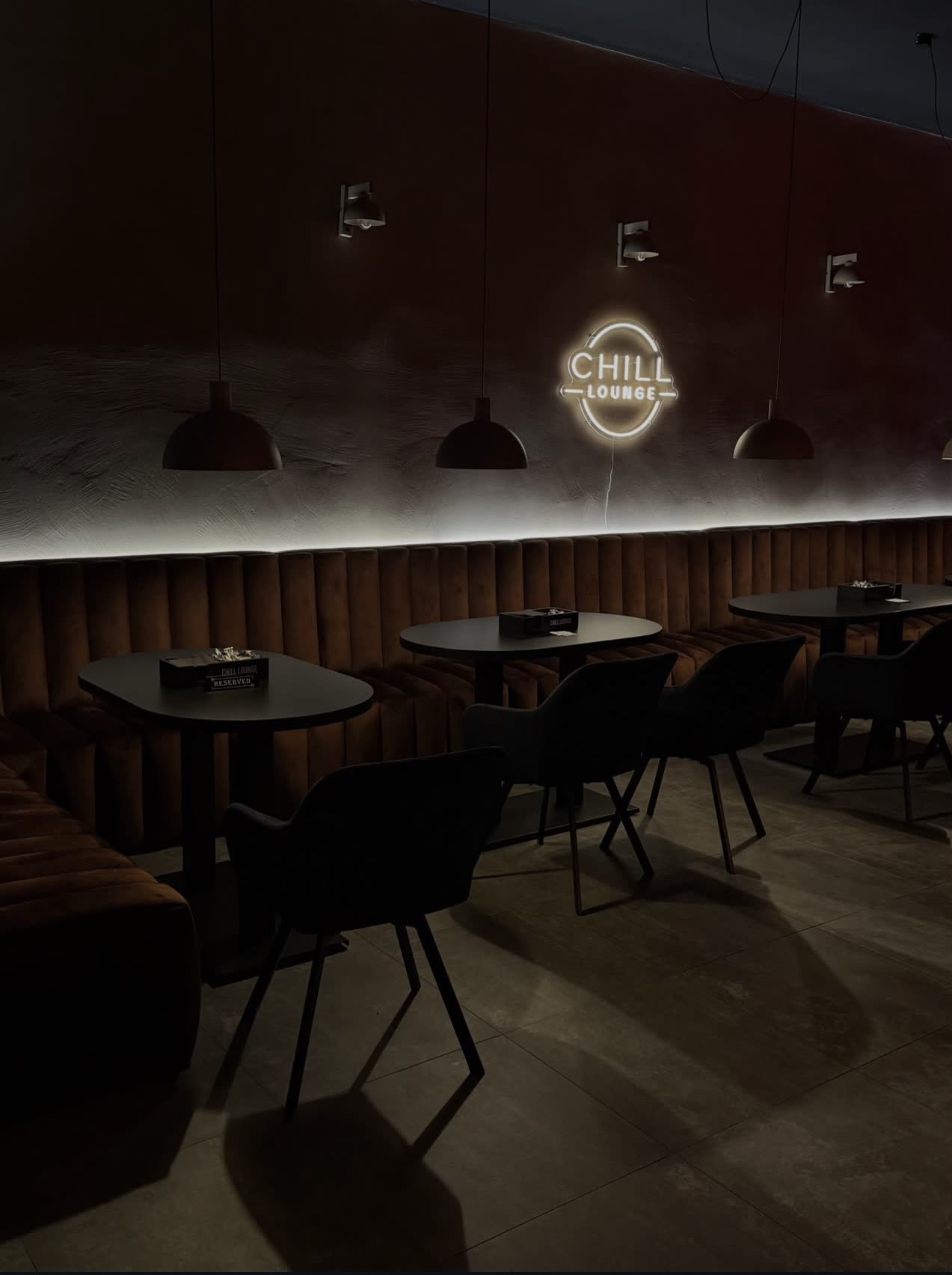 Sala główna Chill Lounge - welurowe kanapy i neon pod ciepłym światłem